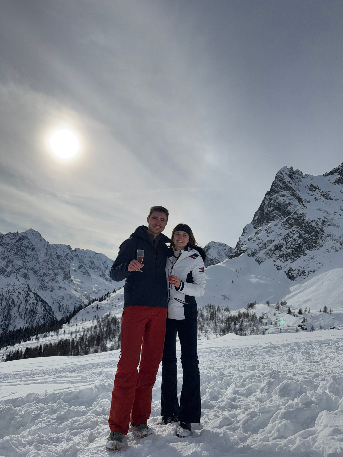 Marianne et Xavier dans la neige, coupes de champagne à la main